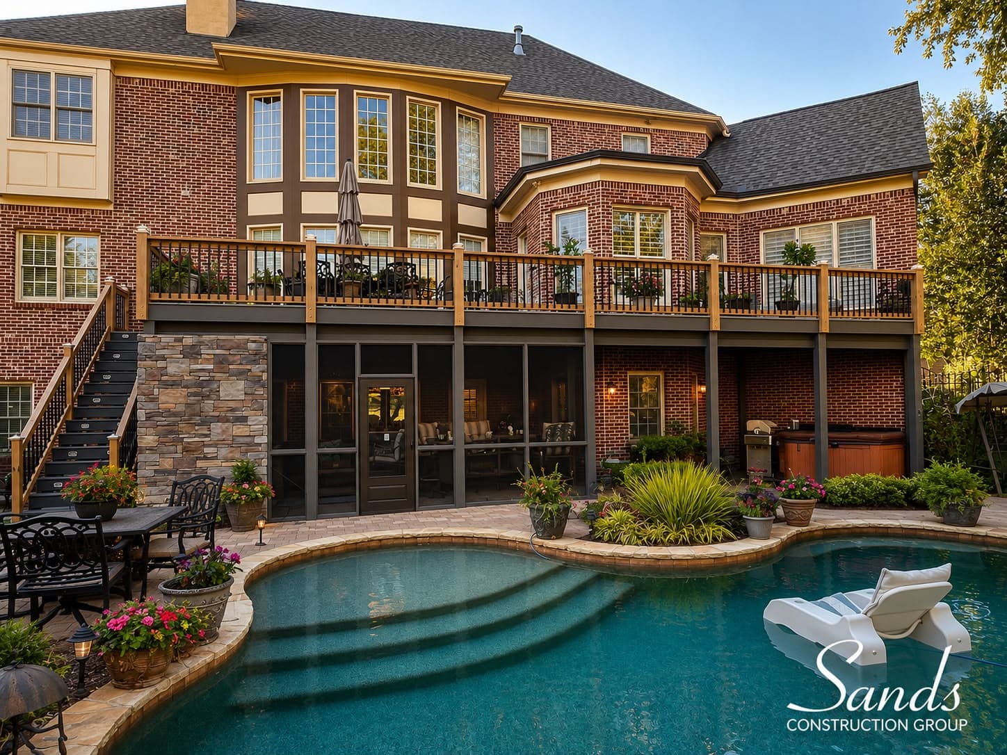 Elevated deck and screened porch overlooking a landscaped backyard pool