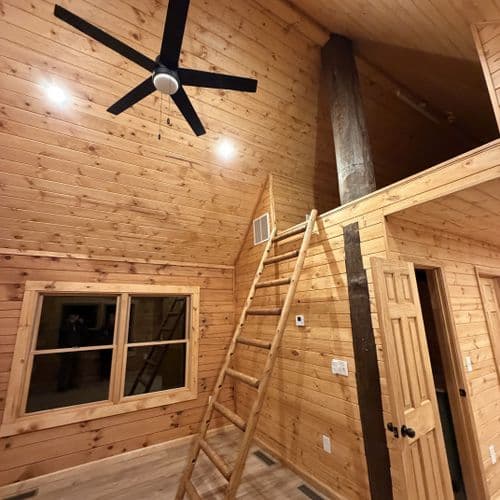 Timber cabin interior with loft and ceiling fan